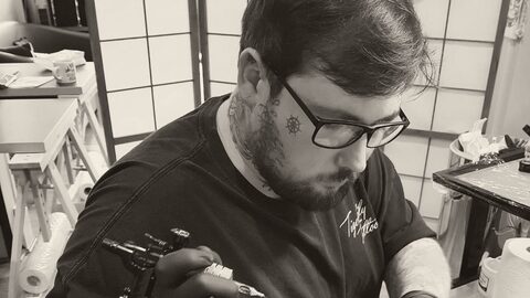 Cal at work, tattooing a design onto a client