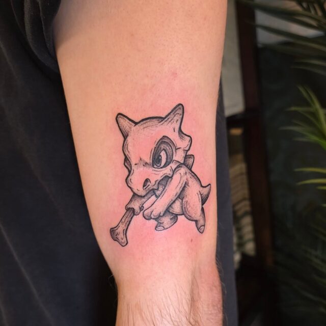 Tattoo of the Pokémon Cubone holding a bone club, on a forearm